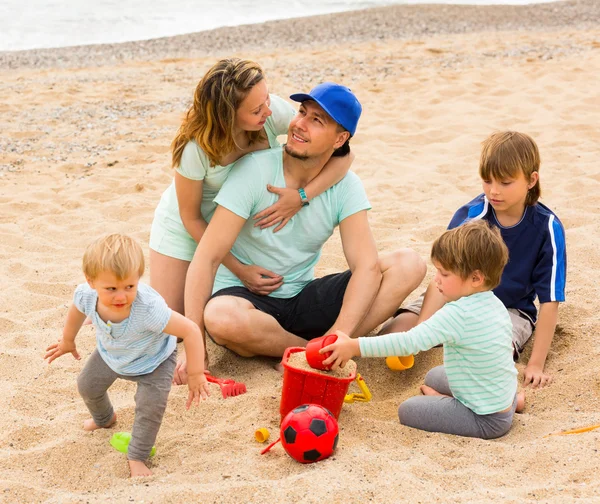 Родители с детьми на берегу моря — стоковое фото