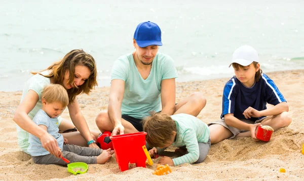 Father and mother with children at seaside — Stock Photo, Image