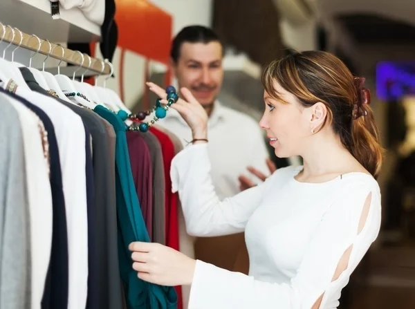 Мужчина и женщина выбирают одежду в бутике — стоковое фото