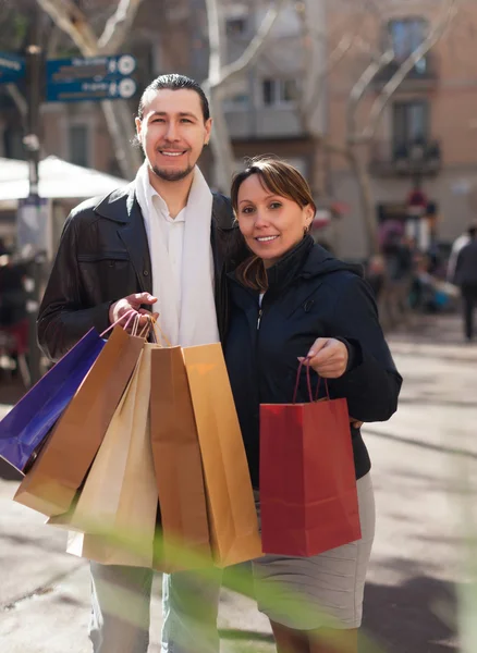 Man and woman with purchases at street — Stock Photo, Image