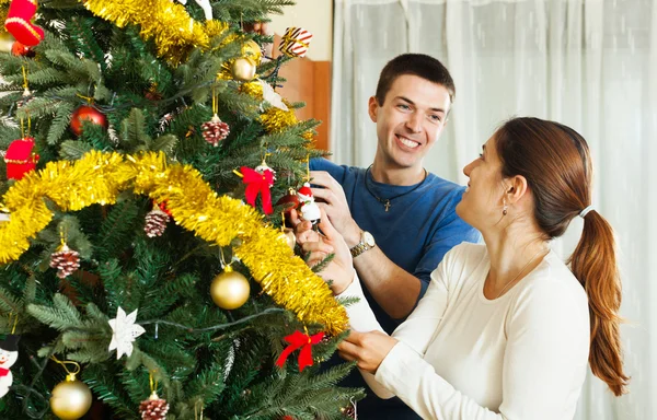 Paar schmückt Weihnachtsbaum — Stockfoto