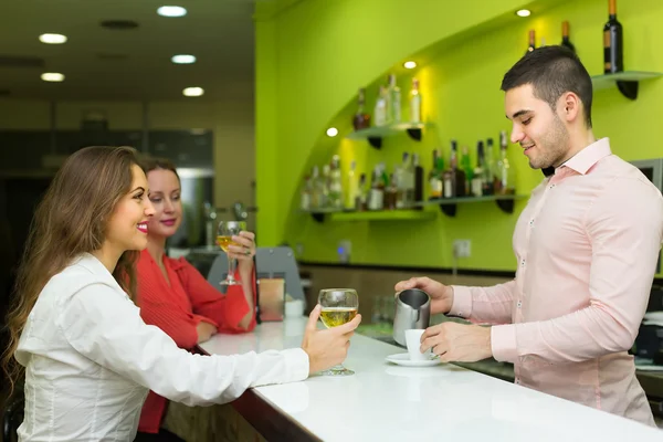 Bartender and smiling women at bar — Stock Photo, Image