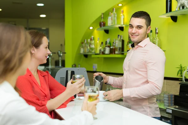 Camarero y mujeres sonrientes en el bar —  Fotos de Stock