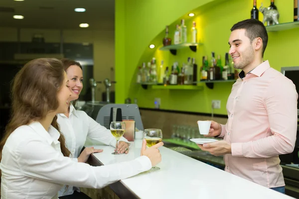 Bartender and smiling women at bar — Stock Photo, Image