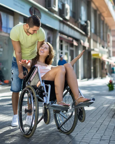 Chica en silla de ruedas con amigo al aire libre — Foto de Stock