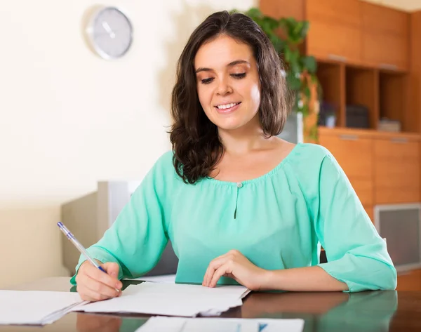 Smiling brunette woman reading document — Stock Photo, Image