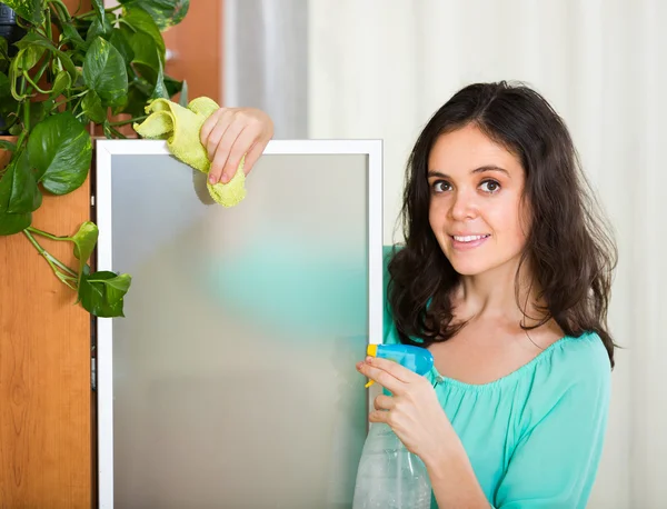 Женщина вытирает стекло мебели — стоковое фото