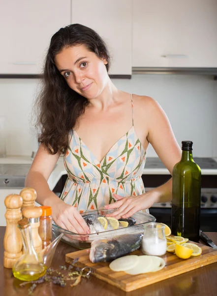 Femme cuisine du poisson à la maison cuisine — Photo