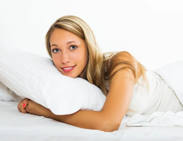 Веселая женщина лежит на кровати — стоковое фото