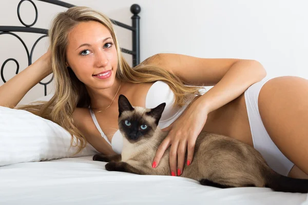 Vrouw met kat in slaapkamer — Stockfoto