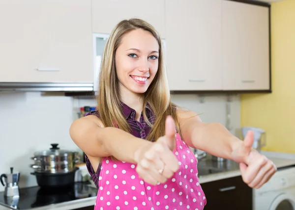 Девушка показала большие пальцы на кухне — стоковое фото