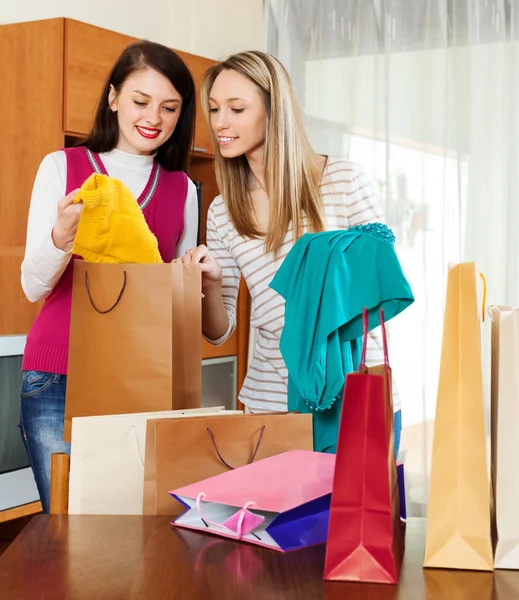Girls looking purchases from shopping bags — Stock Photo, Image
