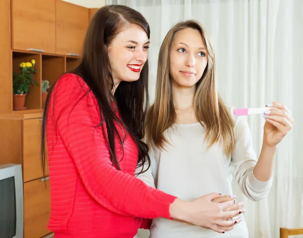 Chicas sonrientes con prueba de embarazo —  Fotos de Stock