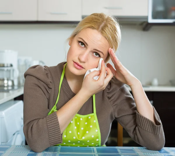 Грустная женщина сидит на кухне — стоковое фото