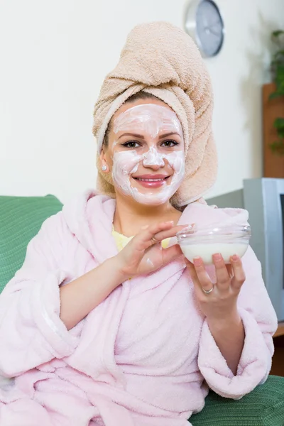 Mujer poniendo tratamiento cosmético en la cara —  Fotos de Stock
