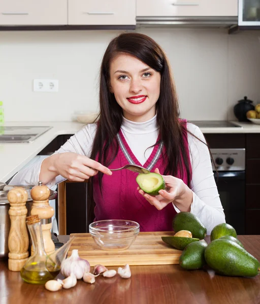Young woman cooking with avocado — Stock Photo, Image