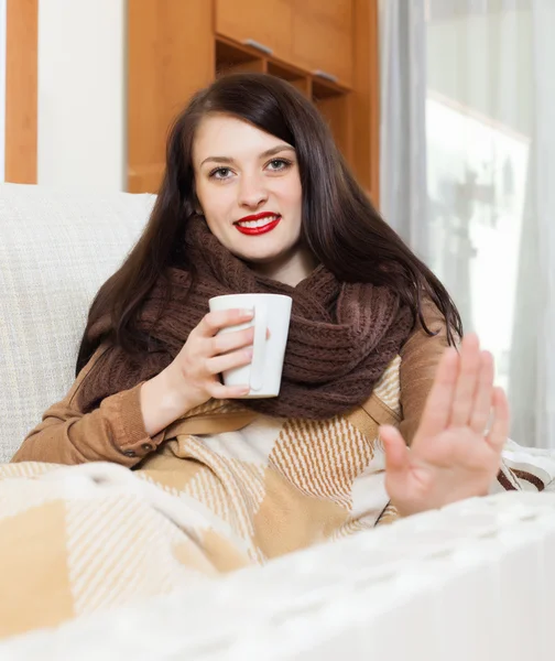 Ragazza con tazza vicino riscaldatore elettrico — Foto Stock