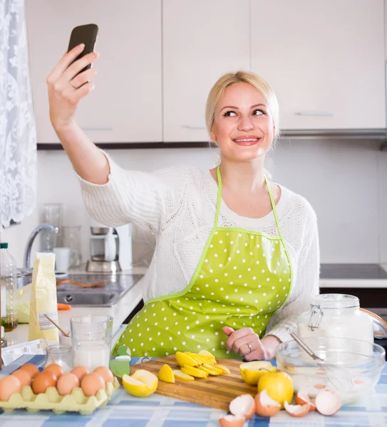 Girl with smartphone at kitchen Stock Image