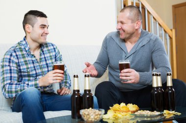 Two man with beer sit and talk clipart