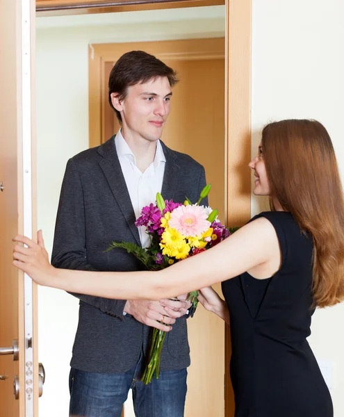 Lyckliga par hälsning i dörröppningen — Stockfoto