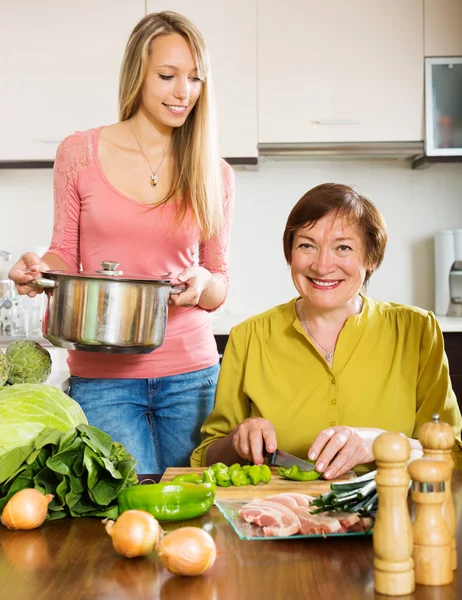 Зрелая женщина с взрослой дочерью приготовления пищи — стоковое фото