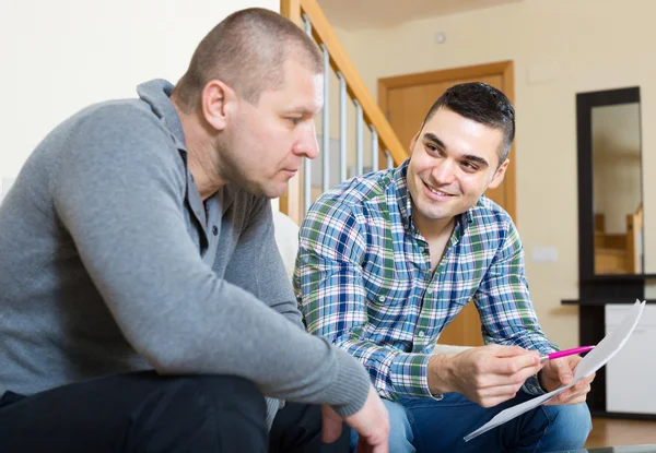 Mann hilft Freund beim Ausfüllen von Dokument — Stockfoto