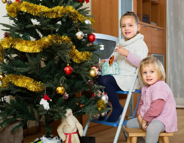 Kleine meisjes kerstboom versieren — Stockfoto