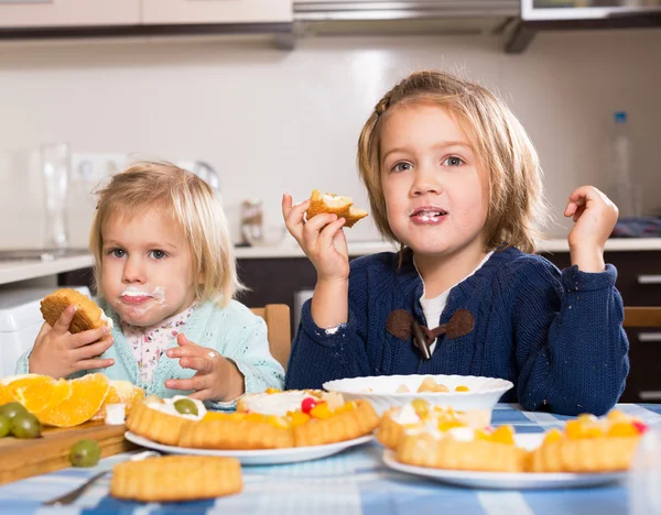 Children eat cakes at kitchen — Stock Photo, Image
