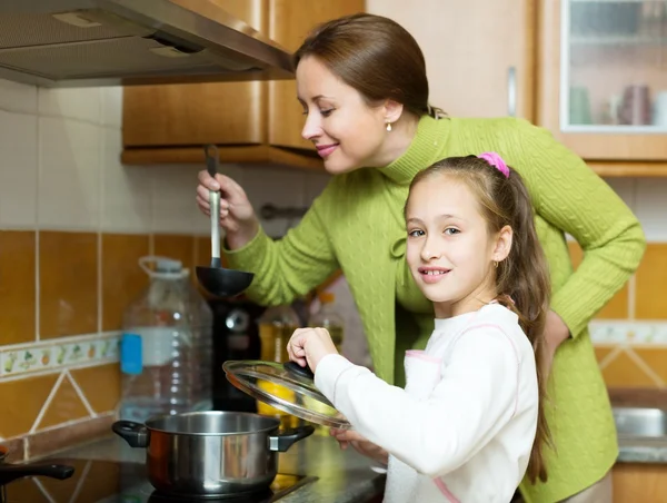 Girl and mother making soup — Stock Photo, Image