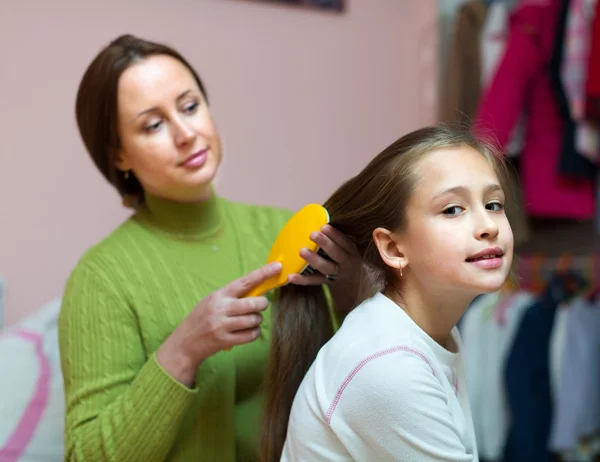 Mamá cuidando de su hija pelo — Foto de Stock