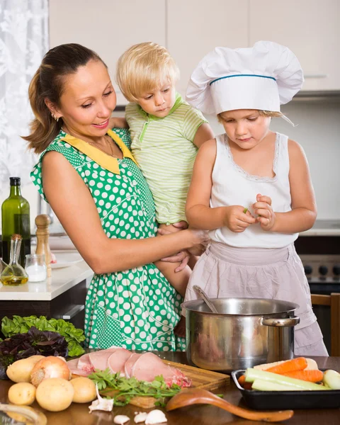 Mãe com duas filhas cozinhar — Fotografia de Stock