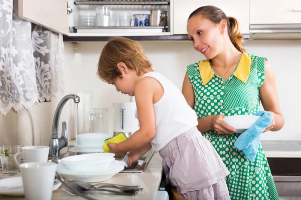 Bebê com mulher lavar pratos — Fotografia de Stock