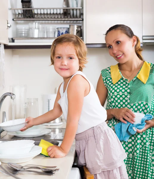 Filha com a mãe lavar pratos — Fotografia de Stock