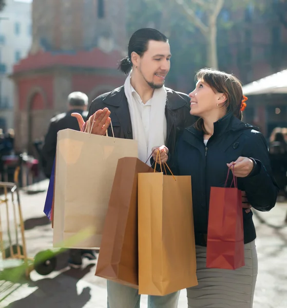 Мужчина и женщина с покупками на улице — стоковое фото