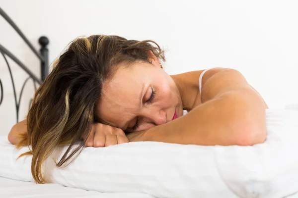 Расстроенная женщина лежит в постели — стоковое фото