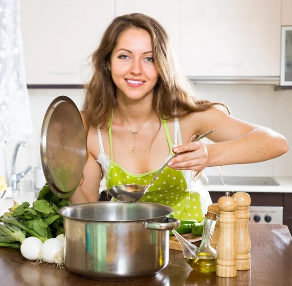 Vrouw koken soep in keuken — Stockfoto