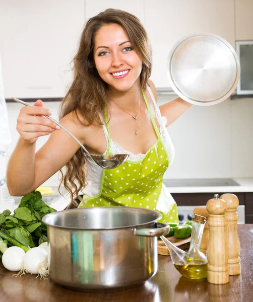 Kvinnan matlagning soppa i köket — Stockfoto