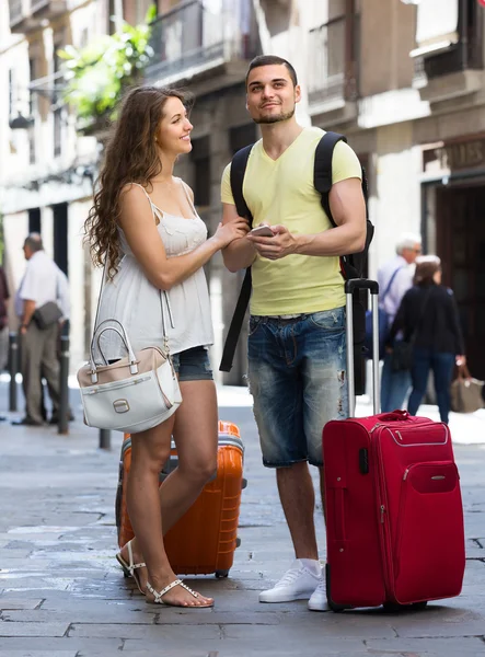 Casal com navegador GPS e bagagem — Fotografia de Stock