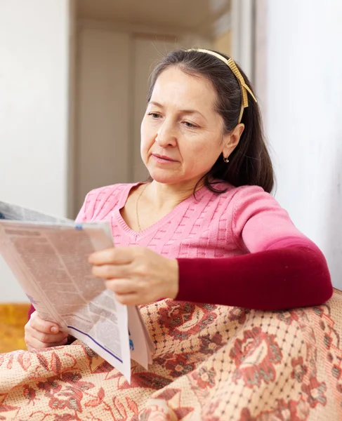 Tankeväckande mogen kvinna med tidningen — Stockfoto