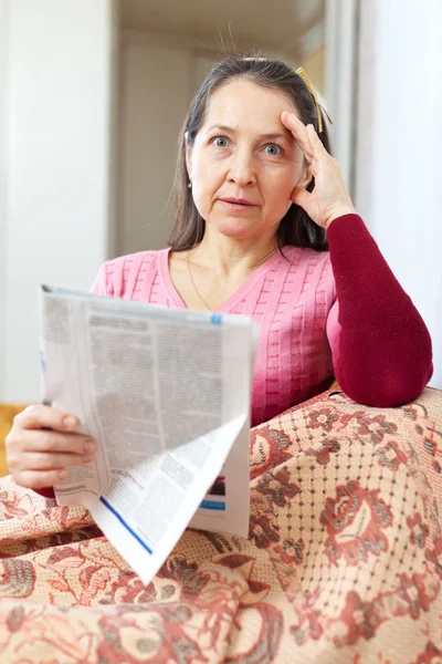 Afflizione donna matura con giornale — Foto Stock