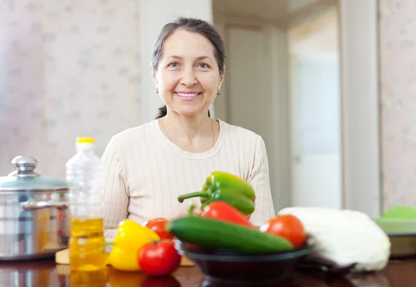 Gelukkig volwassen huisvrouw koken van vegetarische lunch — Stockfoto