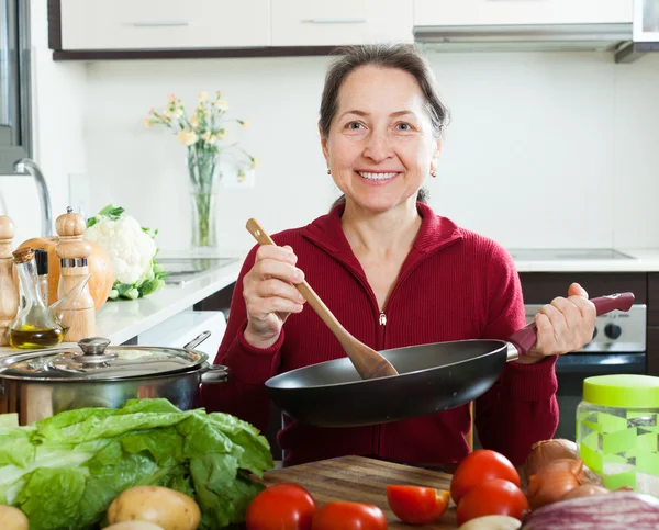 Madura ama de casa con sartén en la cocina casera —  Fotos de Stock