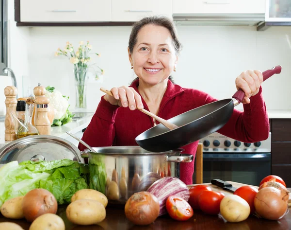 Donna matura cucina pranzo con padella — Foto Stock