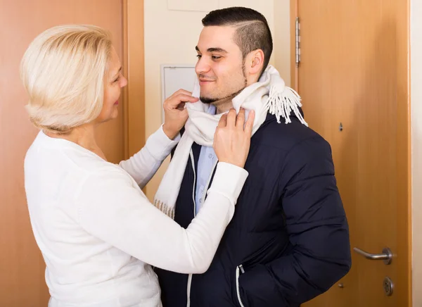 Mãe sênior amarrando um lenço ao filho — Fotografia de Stock