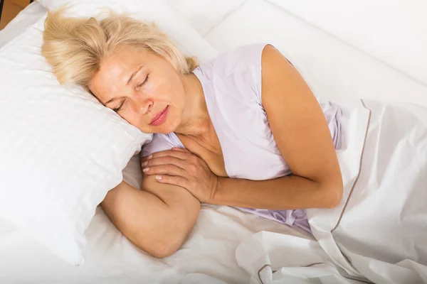 Женщина средних лет спит в постели — стоковое фото