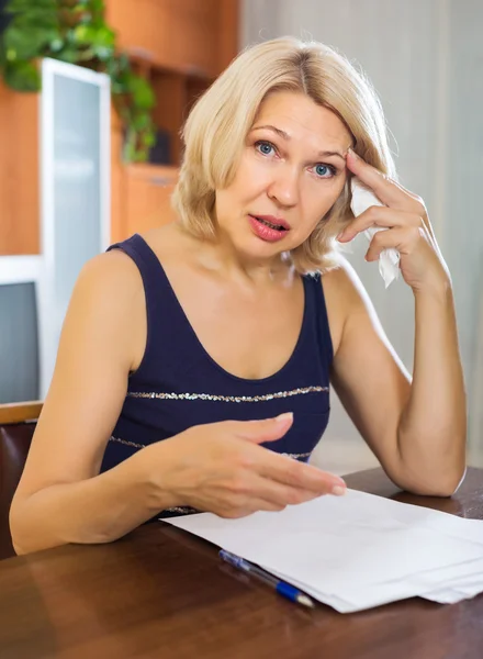 Szomorú nő pénzügyi dokumentumokat tölt ki — Stock Fotó