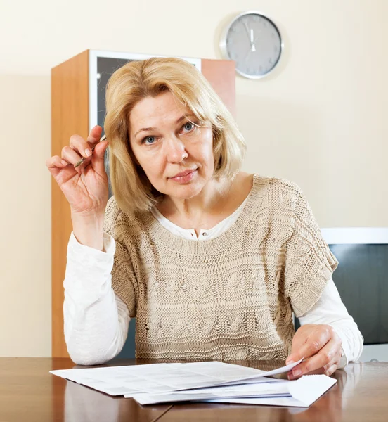 Mature woman filling in paper — Stock Photo, Image