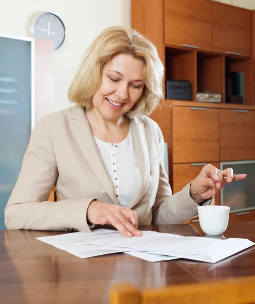 Mature woman with  documents and tea — Stock Photo, Image