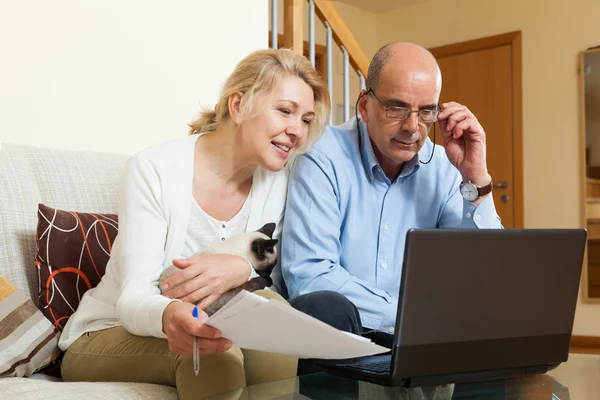 Coppia matura con laptop in casa — Foto Stock