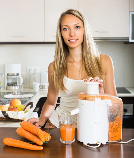 Chica haciendo jugo de zanahoria — Foto de Stock